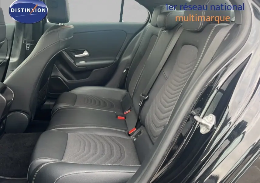 Vue côté droit de l'habitacle arrière d'une Mercedes Classe A 180 Business Line noire avec sièges cuir et tissu gris.