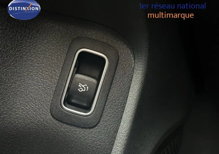 Gros plan sur le bouton d'ouverture du coffre dans l'habitacle noir d'une Mercedes Classe A 180 Business Line 2020.
