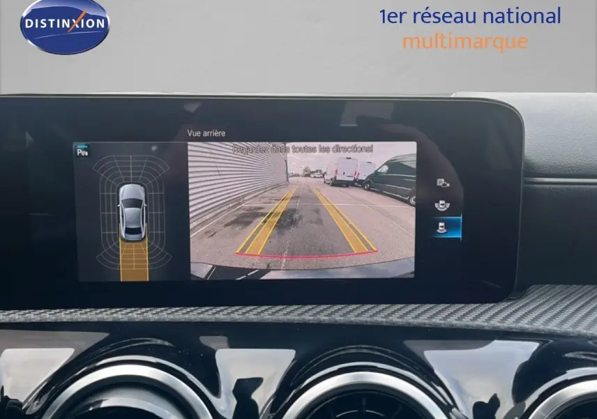 Écran multimédia affichant la caméra de recul et les capteurs de stationnement d'une Mercedes Classe A noire cosmos métal.