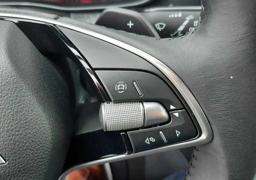 Gros plan sur les commandes multifonctions en métal brossé du volant cuir noir du Skoda Kamiq gris graphite 2025.