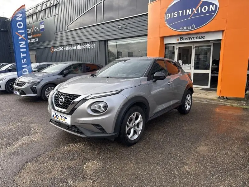 Nissan Juke gris perle métallisé vu en 3/4 avant droit devant un concessionnaire Distinxion.