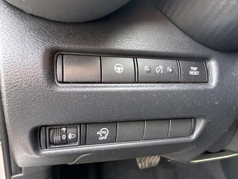 Gros plan sur les commandes noires du tableau de bord côté gauche du Nissan Juke gris perle métallisé 2022.