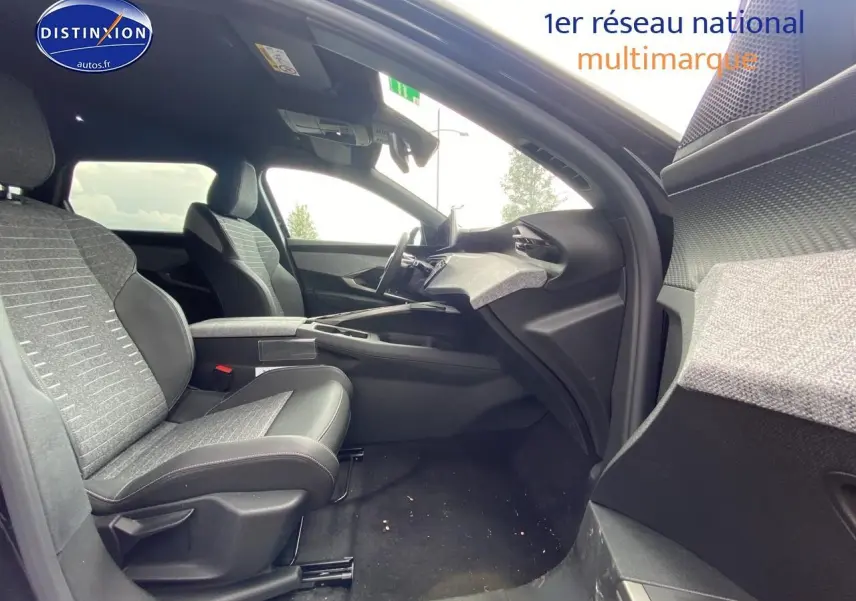 Intérieur avant droit du Peugeot 5008 noir 2025, montrant sièges tissu et cuir, tableau de bord moderne et console centrale.