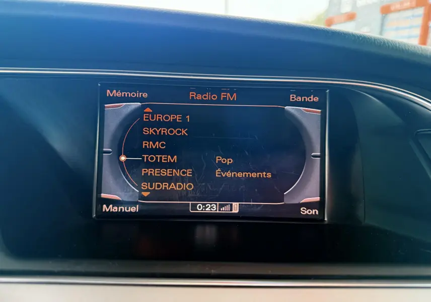 Écran central de l'Audi A5 gris 2011 affichant la liste des radios FM avec sélection sur TOTEM.