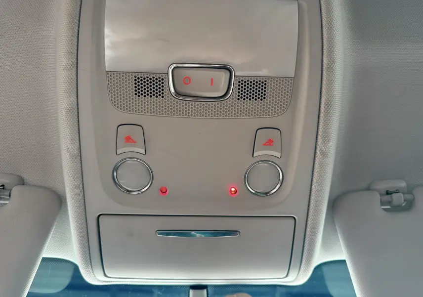 Vue intérieure du plafonnier gris clair de l'Audi A5 avec commandes d'éclairage et deux voyants rouges allumés