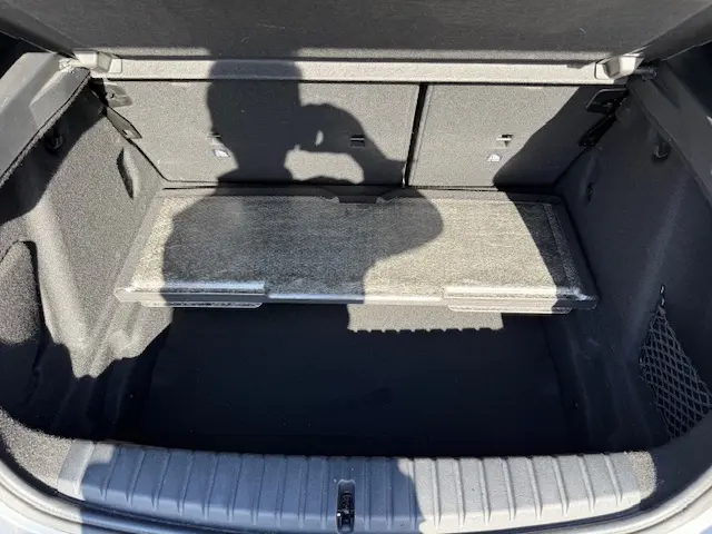 Coffre ouvert de la BMW Série 1 118d Edition Sport gris foncé, montrant le plancher plat et la séparation intérieure.