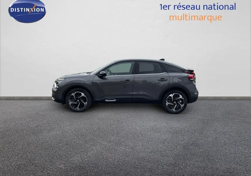 Profil côté gauche d'une Citroën C4 2024 gris platinium métal avec jantes bicolores et toit noir.