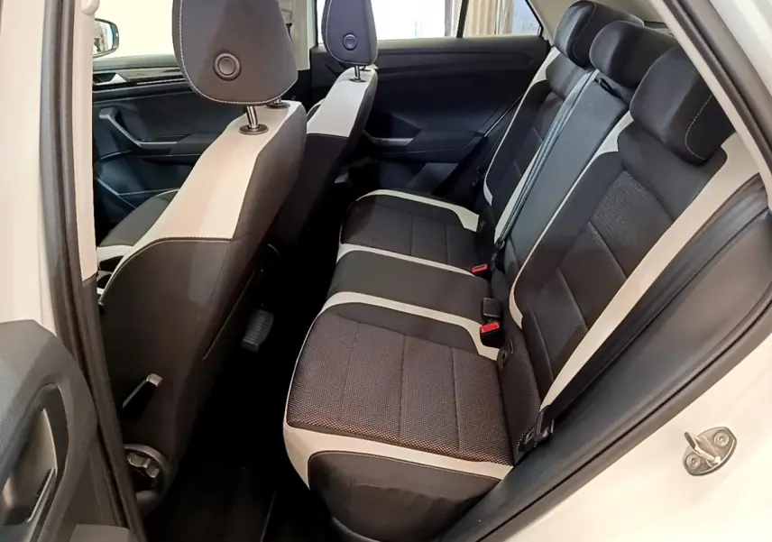Vue intérieure côté droit sur la banquette arrière bicolore noire et beige du Volkswagen T-Roc blanc 2020.