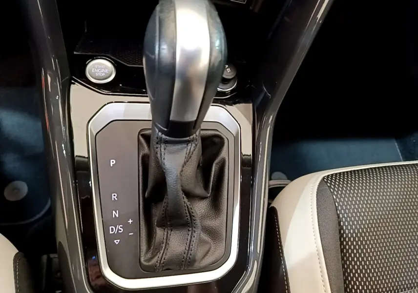 Le levier de vitesse automatique noir et argenté du Volkswagen T-Roc 1.5 TSI, avec bouton démarrage visible, vue intérieure rapprochée.