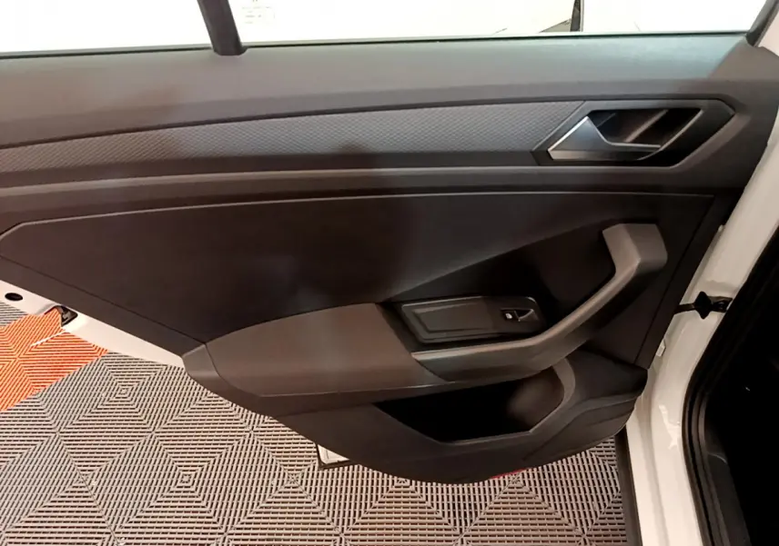 Vue rapprochée de la porte avant gauche blanche d'un Volkswagen T-Roc 2020 avec garniture intérieure noire.