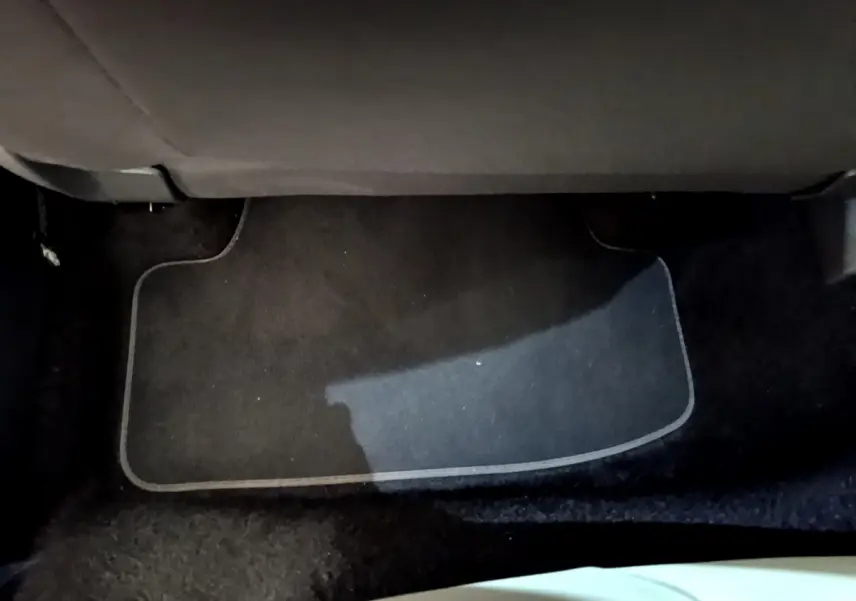 Tapis de sol noir sous le siège arrière d'un Volkswagen T-Roc blanc 2020, vue intérieure au sol.