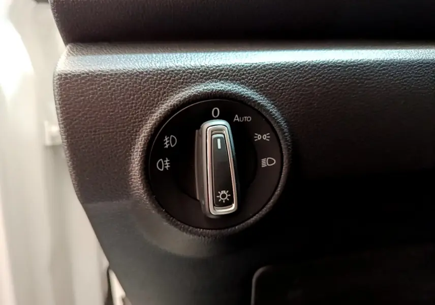 Gros plan sur le sélecteur d'éclairage noir du tableau de bord du Volkswagen T-Roc blanc, version 2020.