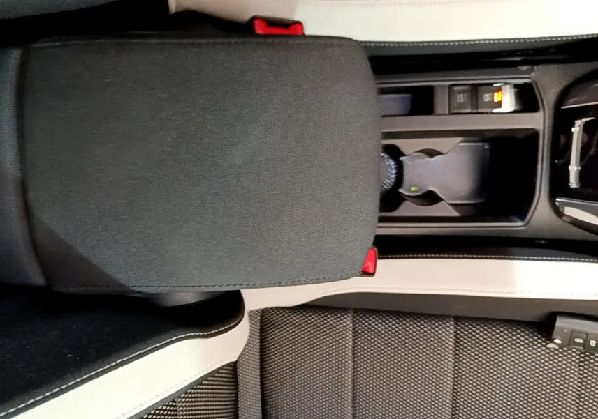 Vue plongeante sur l'accoudoir central et console noire avec porte-gobelets du Volkswagen T-Roc 1.5 TSI blanc 2020.