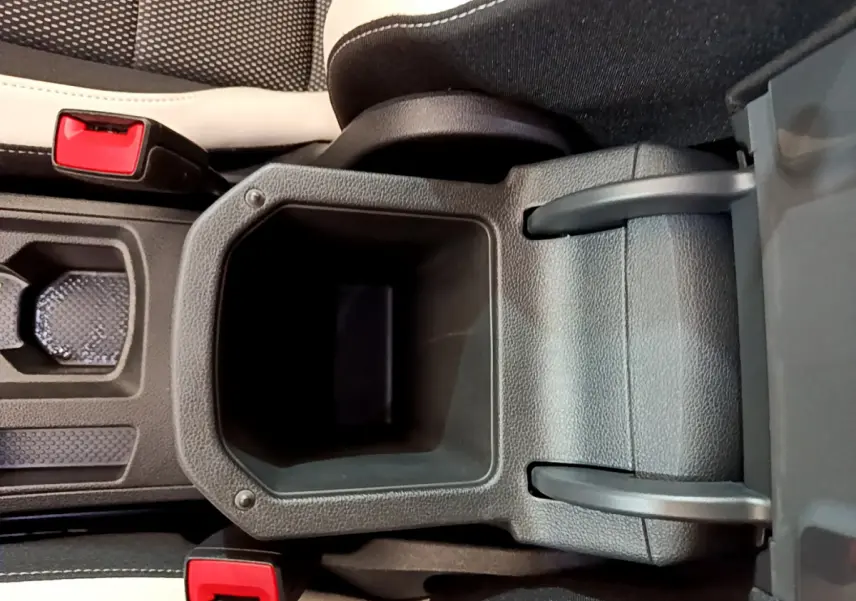 Gros plan sur la console centrale noire avec accoudoir et ceintures rouges du Volkswagen T-Roc blanc 2020.