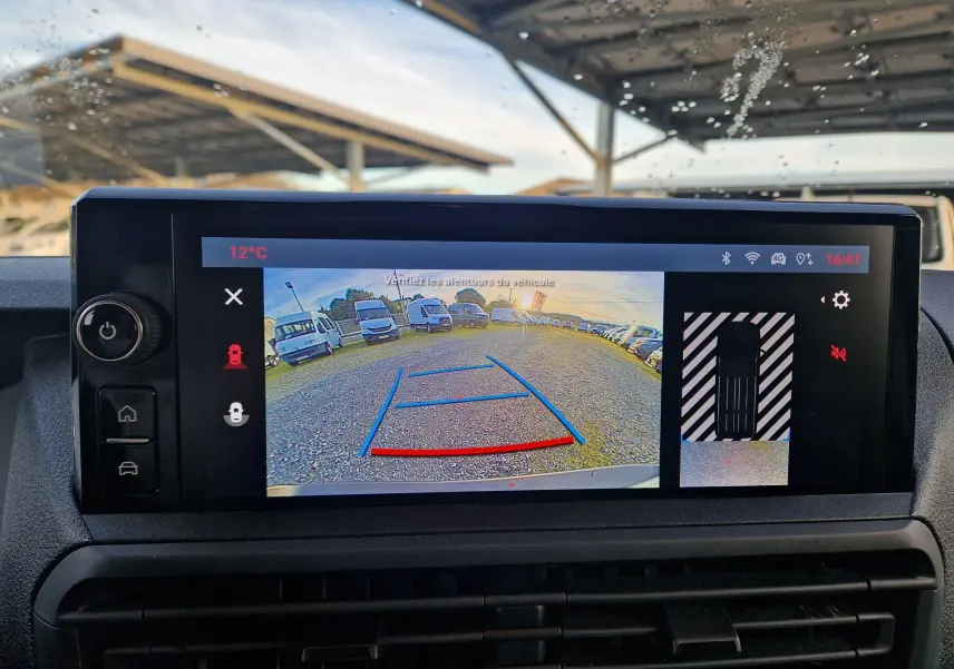 Écran de caméra de recul du FIAT Scudo Fourgon blanc 2024 affichant vue arrière avec lignes de guidage et parking gravillonné.