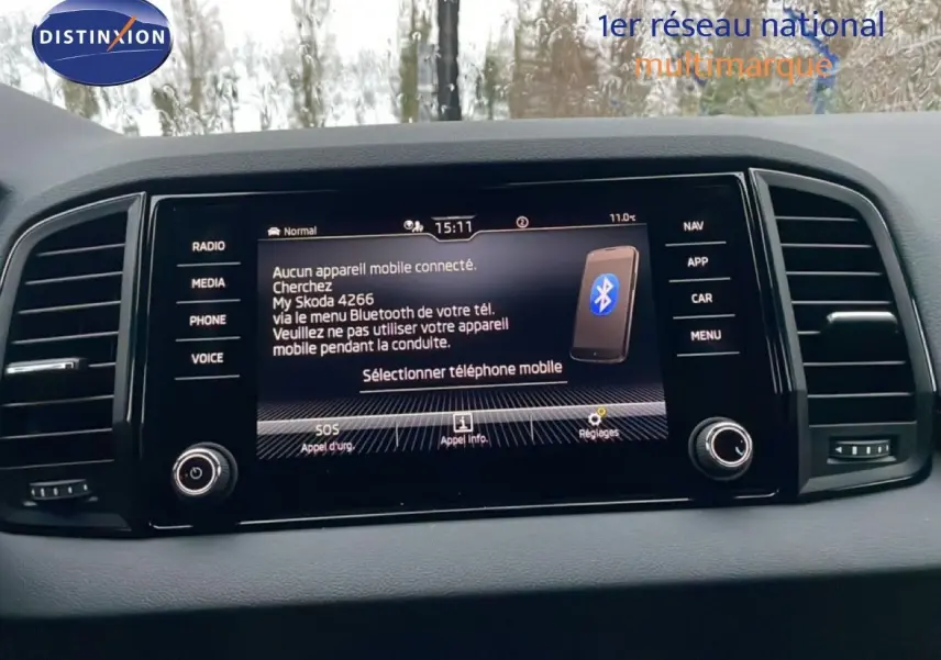 Tableau de bord avec écran tactile central du Skoda Karoq gris argent, affichant menu Bluetooth et options connectées.