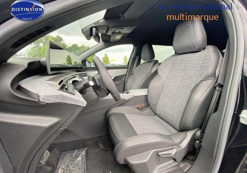 Vue intérieure côté conducteur du Peugeot 5008 Hybrid 145 allure e-dcs6 2025 noir, sièges tissu gris et cuir noir.