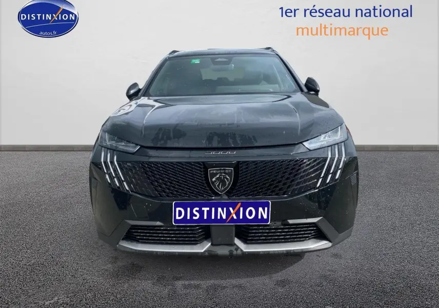 Vue avant d'un Peugeot 5008 noir 2025 avec calandre distinctive et feux LED verticaux allumés.