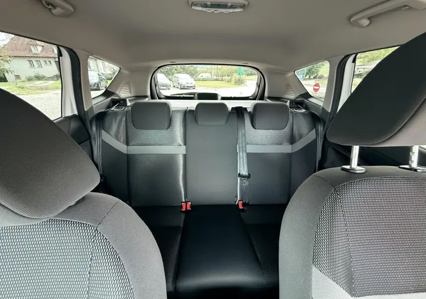 Vue intérieure arrière du Ford Kuga 2012 montrant les sièges arrière en tissu gris et noir avec appuie-têtes et ceinture centrale.