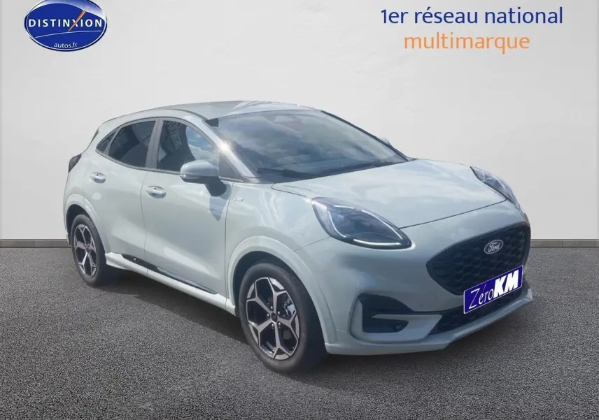 Ford Puma gris cactus en 3/4 avant droit, avec jantes 17 pouces et phares LED allumés.