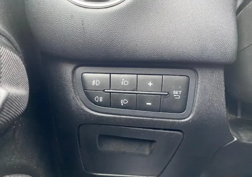 Gros plan sur les commandes d'éclairage et réglages du tableau de bord d'une Fiat Grande Punto gris métallisé.