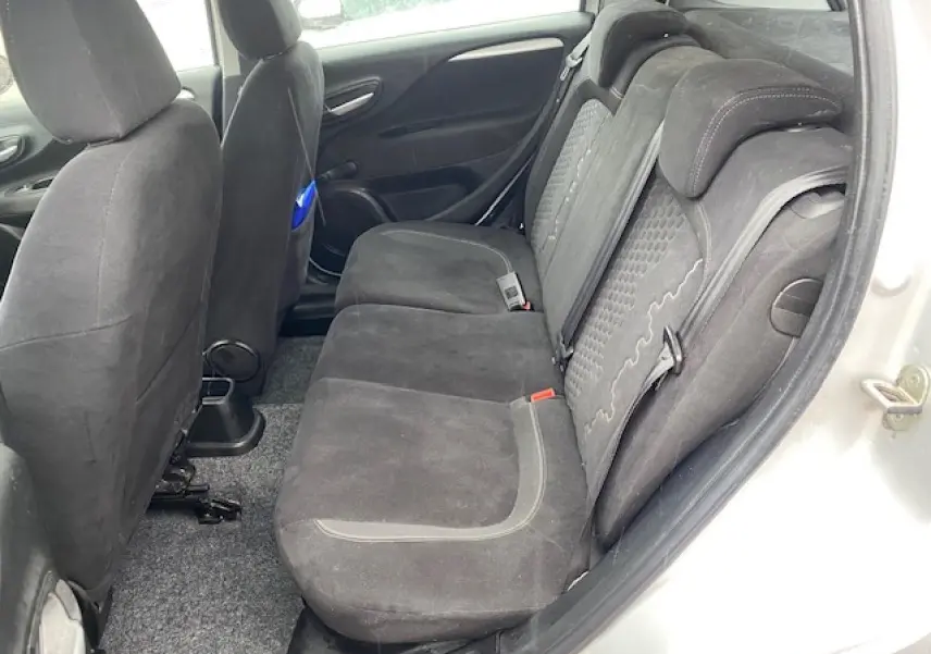 Vue côté droit de la banquette arrière en tissu noir de la Fiat Grande Punto gris métallisé, avec porte ouverte.