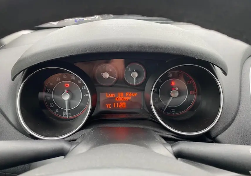 Vue rapprochée du tableau de bord de la Fiat Grande Punto gris, affichant le compteur et l'ordinateur de bord.