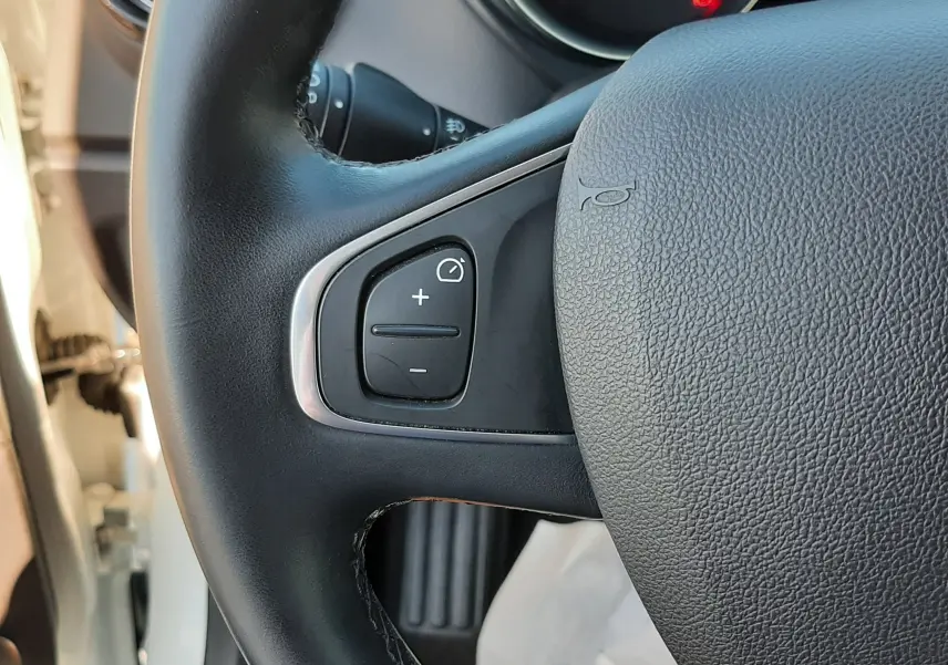 Gros plan sur le volant noir de la Renault Captur 2019, montrant les commandes de régulateur de vitesse côté gauche.