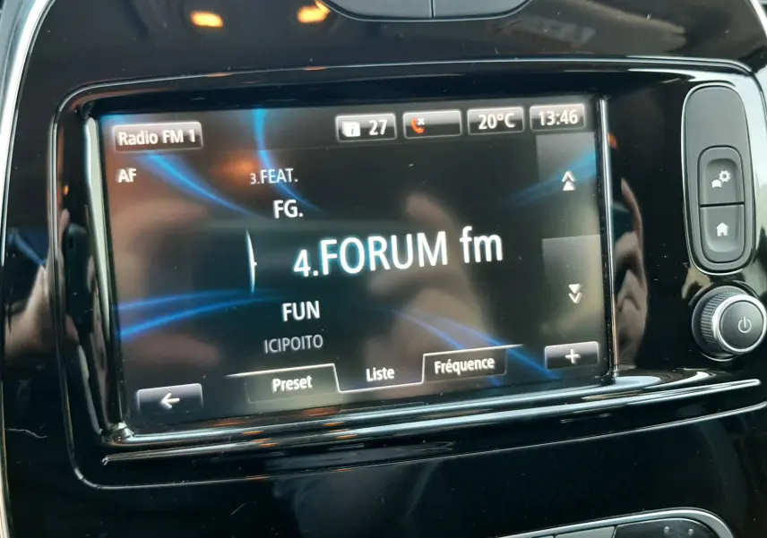 Écran tactile central du Renault Captur blanc nacré 2019 affichant la radio FM avec commandes climatisation visibles.