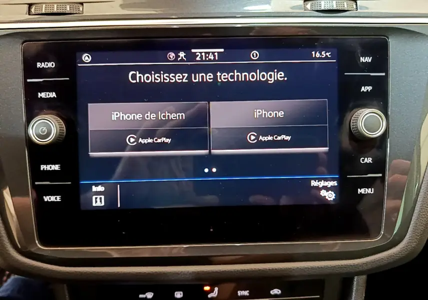 Écran tactile central du Volkswagen Tiguan 2.0 TDI noir, affichant le choix Apple CarPlay pour deux iPhone.