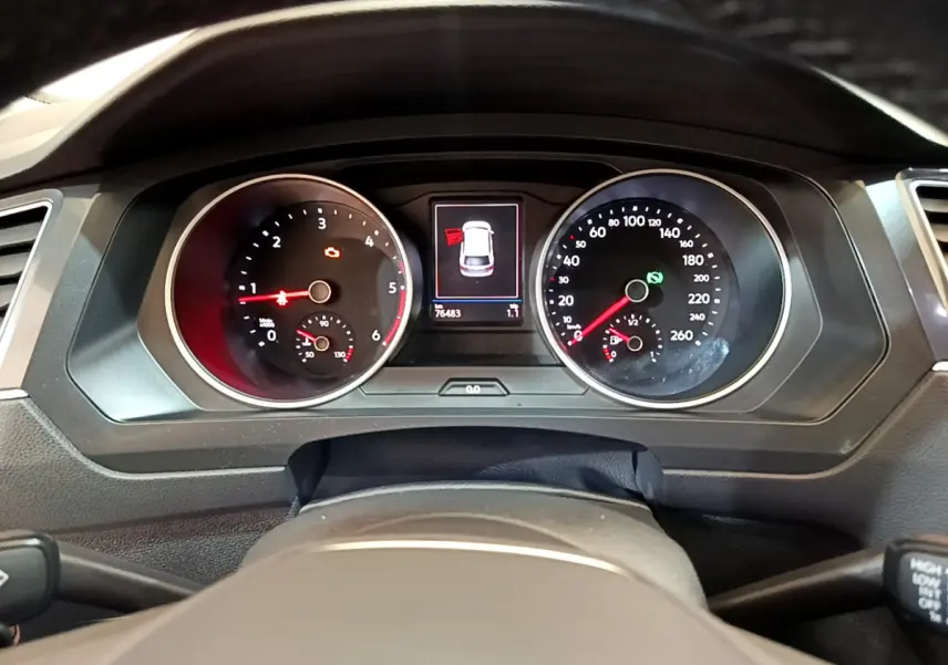 Vue intérieure du tableau de bord du Volkswagen Tiguan noir 2021, avec écran tactile et volant cuir multifonctions.