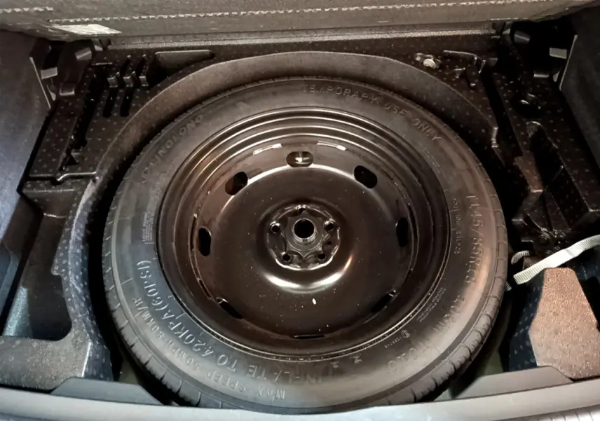 Roue de secours noire vue de dessus dans le coffre du Volkswagen Tiguan 2.0 TDI 150 DSG7 Life Business 2021.
