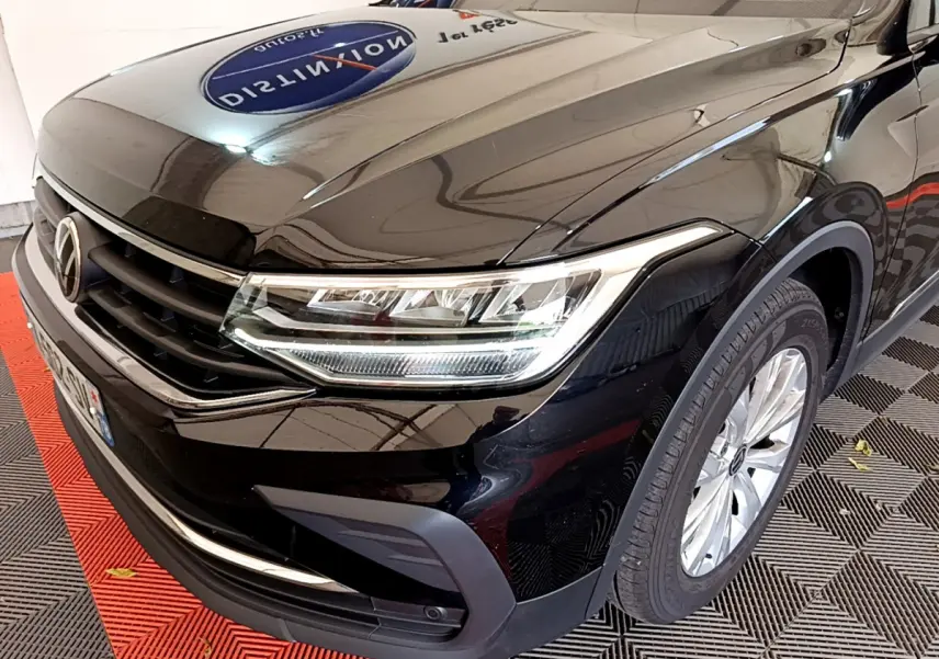 Vue 3/4 avant droit d'un Volkswagen Tiguan noir 2021 avec phares LED et jantes alliage argentées.