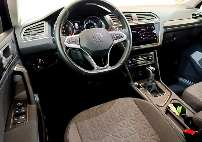Vue intérieure du Volkswagen Tiguan 2.0 TDI 150 DSG7 Life Business, tableau de bord et volant cuir noir au centre.