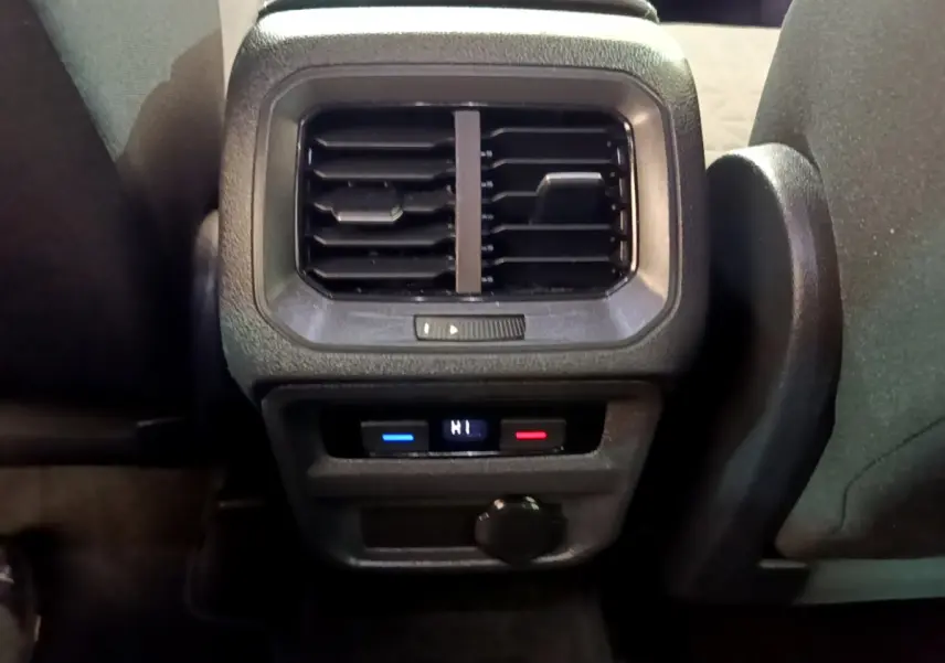 Vue rapprochée des aérateurs arrière et commandes de climatisation digitale du Volkswagen Tiguan noir 2021.