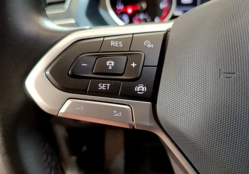 Gros plan sur les commandes multifonctions côté gauche du volant cuir du Volkswagen Tiguan noir 2021.