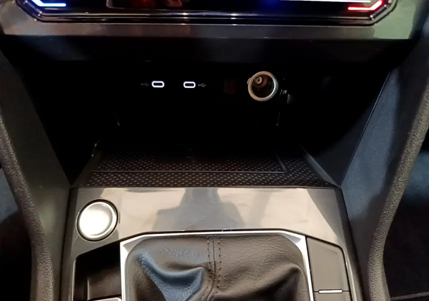 Gros plan sur la console centrale du Volkswagen Tiguan 2021 noire, avec levier de vitesse cuir et ports USB visibles.