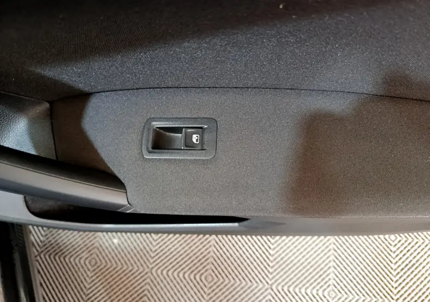 Détail de la commande de verrouillage de porte sur la garniture intérieure noire d'une Volkswagen Tiguan 2021.