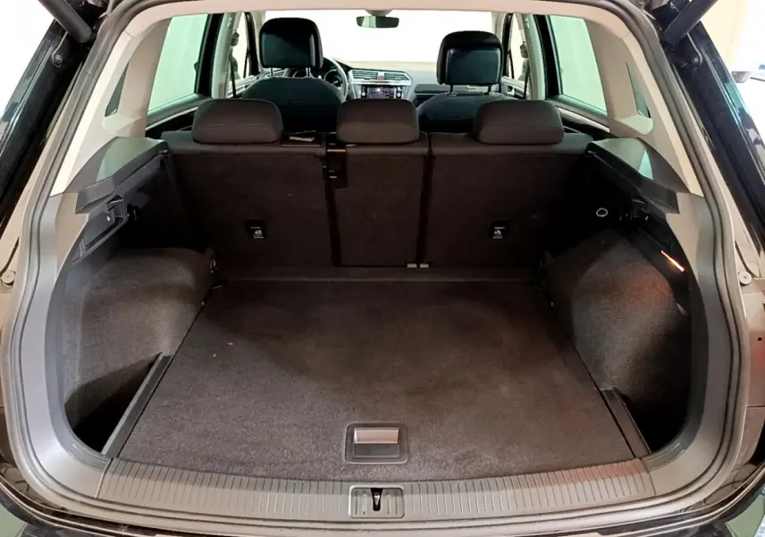 Coffre spacieux ouvert d'un Volkswagen Tiguan noir 2021, vue arrière avec banquette arrière en tissu noir.