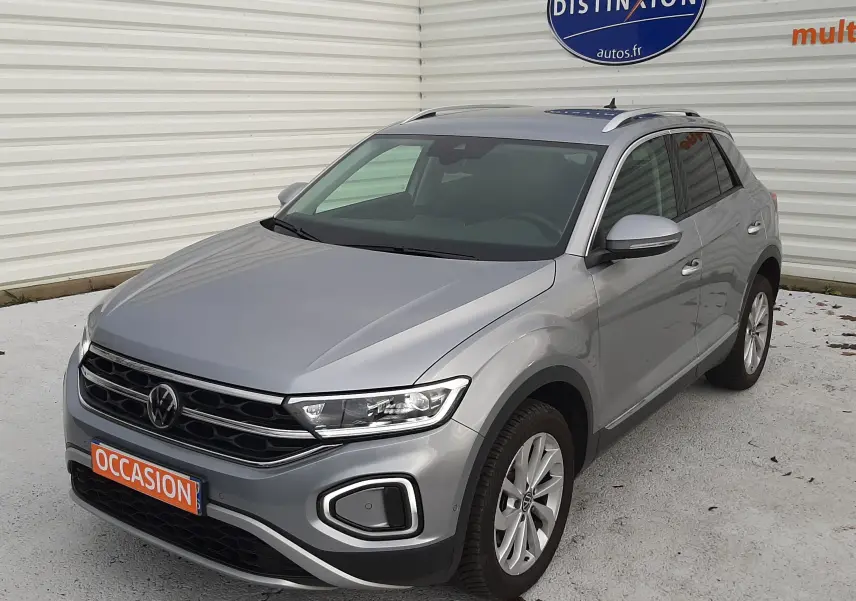 Volkswagen T-Roc gris pyrite en 3/4 avant droit, SUV compact avec vitres arrière surteintées et jantes alliage.