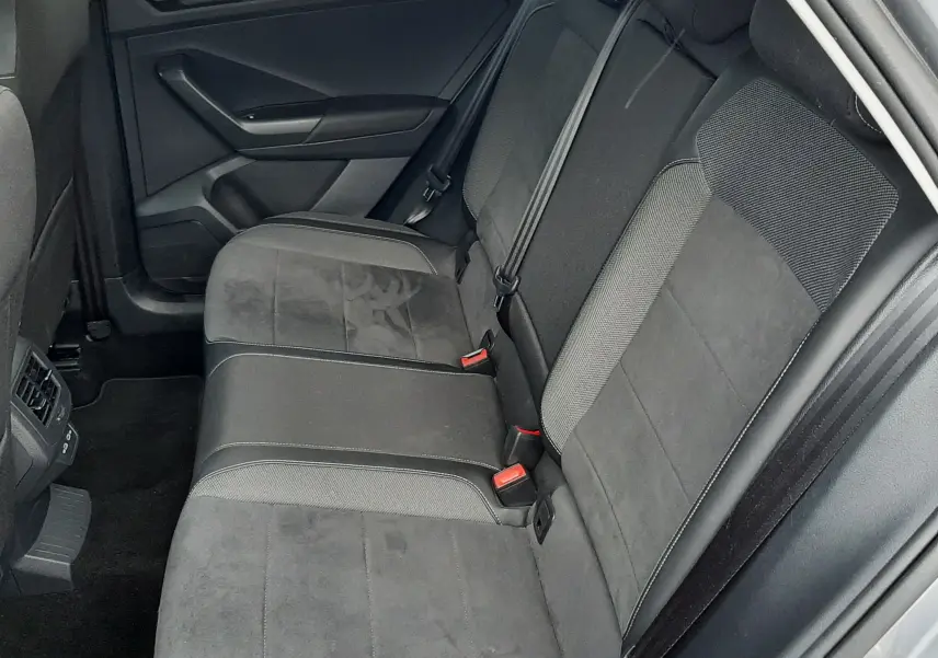 Vue intérieure côté conducteur du Volkswagen T-Roc 2.0 TDI 150 CH STYLE DSG7 avec sièges tissu noir et accoudoir central.