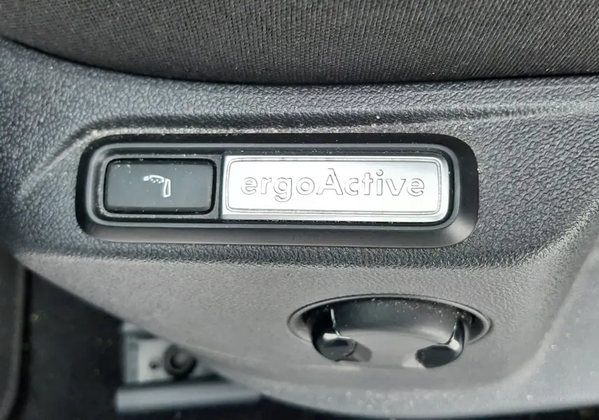 Gros plan sur les commandes de lève-vitres et rétroviseurs côté conducteur du Volkswagen T-Roc gris pyrite 2023.