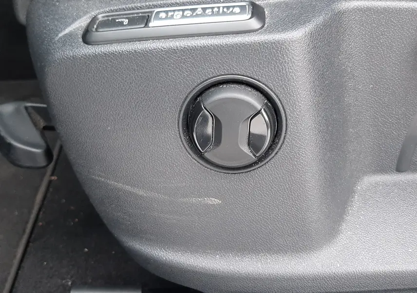 Gros plan sur la commande ergoActive du siège intérieur du Volkswagen T-Roc gris pyrite 2023.