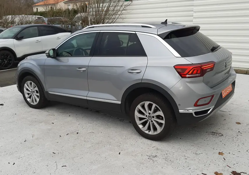 Gros plan sur l'attelage amovible noir logé dans le coffre du Volkswagen T-Roc gris pyrite 2023.