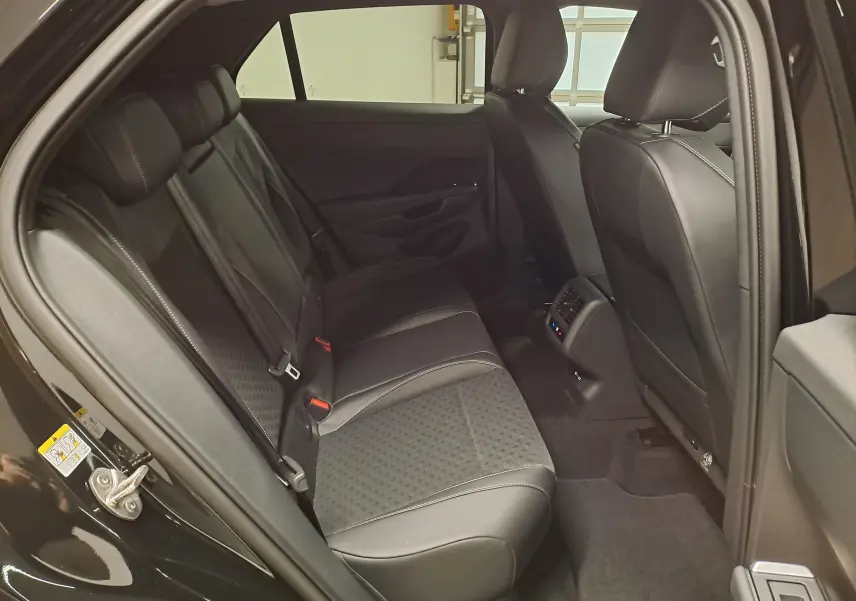 Vue intérieure côté gauche des sièges arrière en cuir noir avec surpiqûres blanches du Volkswagen T-Roc Noir Ébène 2026 R-Line.