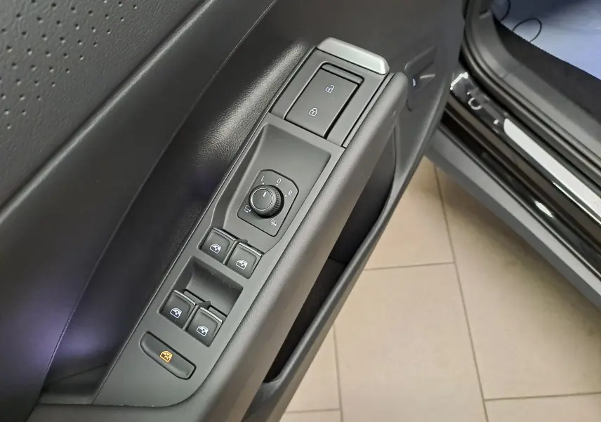 Gros plan sur la commande des vitres et rétroviseurs côté conducteur du Volkswagen T-Roc noir ébène 2026 R-Line.