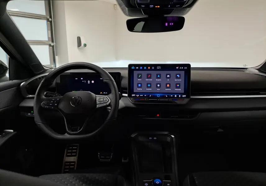 Vue intérieure avant du Volkswagen T-Roc 2026 noir ébène, avec tableau de bord digital et écran tactile central lumineux.