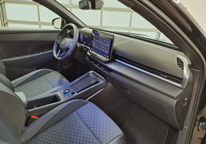 Vue intérieure côté conducteur du Volkswagen T-Roc 2026 noir, avec tableau de bord moderne et écran tactile central.