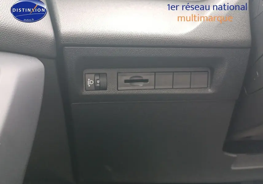 Détail intérieur montrant les commandes d'éclairage sur le tableau de bord d'une Peugeot 308 SW gris sélénite.