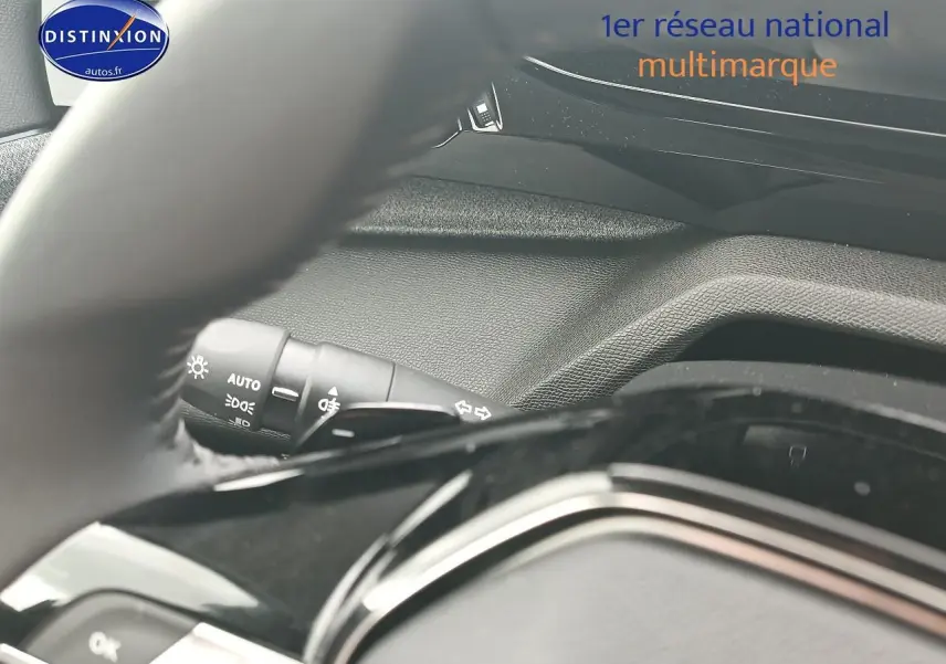 Vue rapprochée du tableau de bord et du volant noir de la Peugeot 308 SW gris sélénite, mettant en valeur les commandes lumineuses.